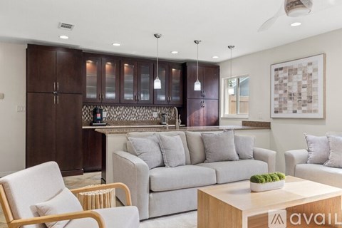 A living room with a grey couch, a wooden coffee table, and a large painting on the wall.