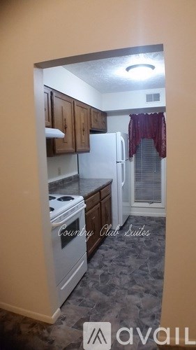 A kitchen with a white stove top oven and a white refrigerator.