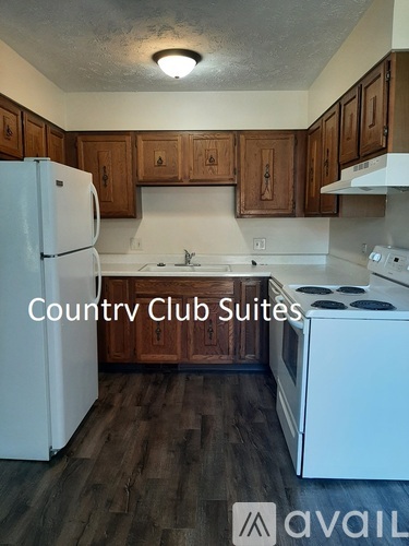 A kitchen with wooden cabinets and white appliances is available for rent.