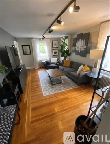 A living room with a grey couch and a wooden floor.