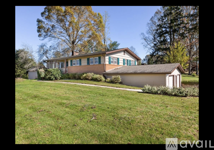 A house with a green lawn and trees in the background.