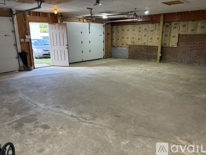 A spacious garage with a concrete floor and a brick wall.