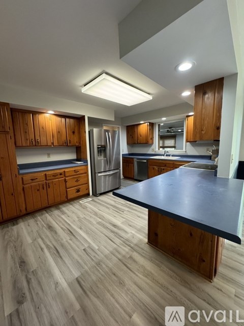 A kitchen with wooden cabinets and a black countertop.