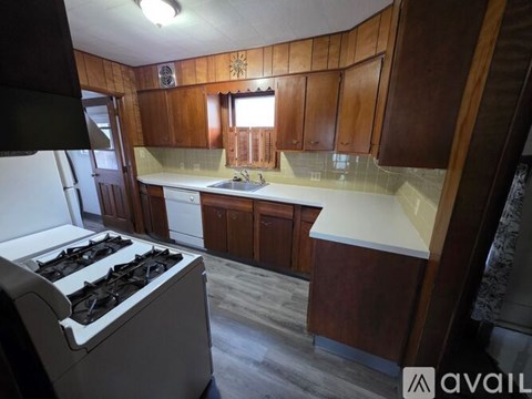 A kitchen with wooden cabinets and a white stove top.