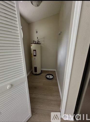 A small room with a white door and a white wall.