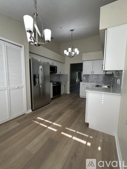 A kitchen with wooden floors and a refrigerator.