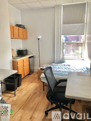 A room with a desk, chair, and bed.