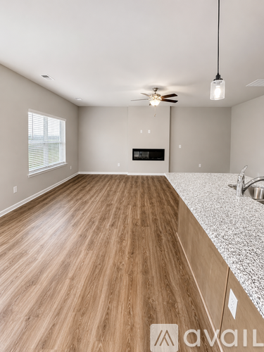A room with wooden floors and a ceiling fan.