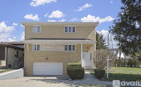 A two-story house with a garage is for sale.