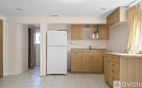 A kitchen with a white refrigerator and wooden cabinets.
