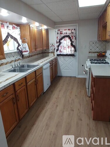 A kitchen with wooden cabinets and a white stove top oven.