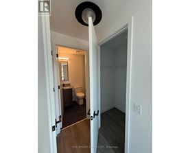 A bathroom with a toilet, sink, and mirror.