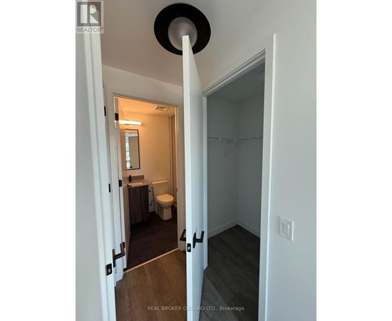A bathroom with a toilet, sink, and mirror.