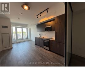 A modern kitchen with dark wood cabinets and a stainless steel stove top oven.