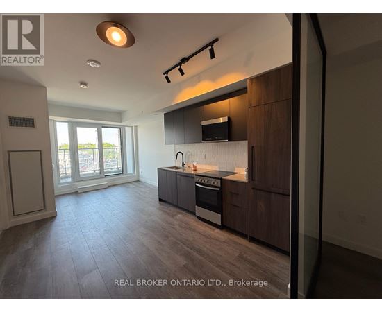 A modern kitchen with dark wood cabinets and a stainless steel stove top oven.