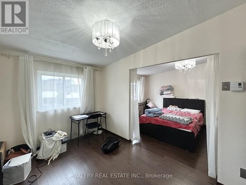 A bedroom with a bed, desk, and chair.