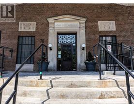 A brick building with a large doorway and steps leading up to it.