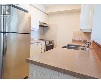 A kitchen with a stainless steel refrigerator and a sink.