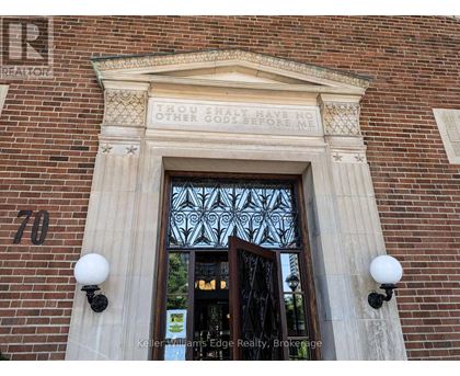 A brick building with a glass door and a sign that says "Keller Williams Edge Realty Brokerage.".
