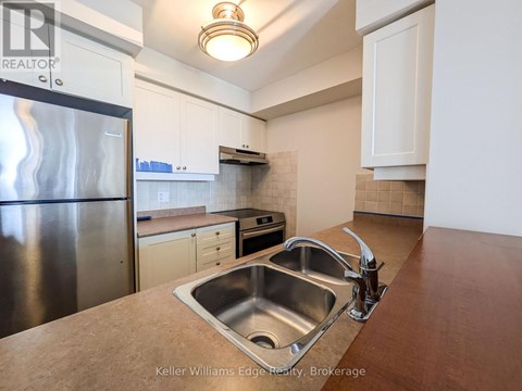 A kitchen with a stainless steel refrigerator and a sink.