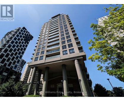 A tall building with a balcony and columns in front of a tree.