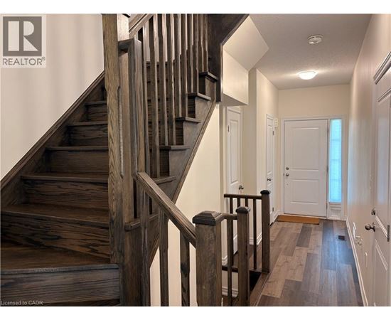 A wooden staircase with a metal railing.