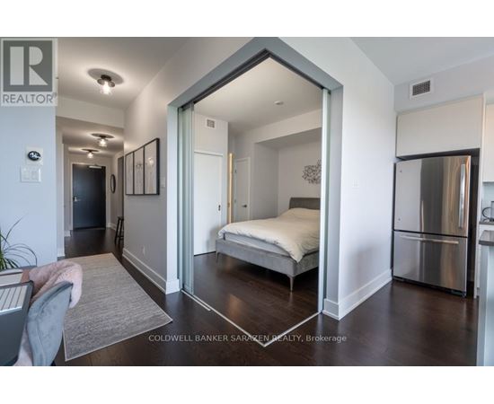 A bedroom with a bed, dresser, and mirror.