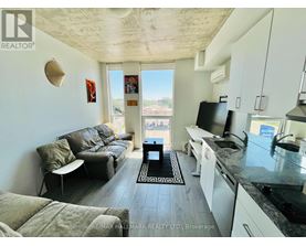 A living room with a couch, chair, and a television.