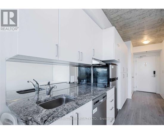 A modern kitchen with granite countertops and stainless steel appliances.