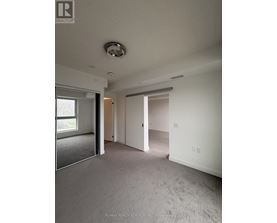 A spacious room with a carpeted floor and a ceiling light fixture.