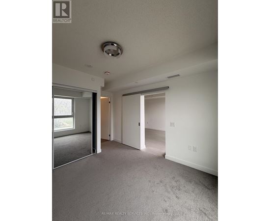 A spacious room with a carpeted floor and a ceiling light fixture.