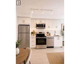 A modern kitchen with white cabinets and stainless steel appliances.