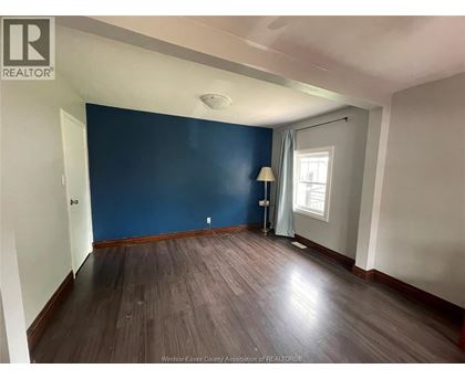 A room with wooden flooring and a blue wall.