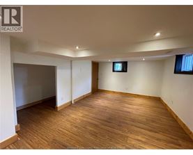 A room with wooden flooring and white walls.