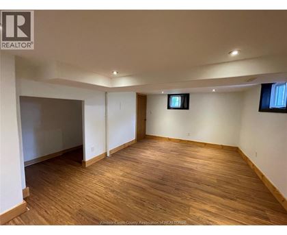 A room with wooden flooring and white walls.