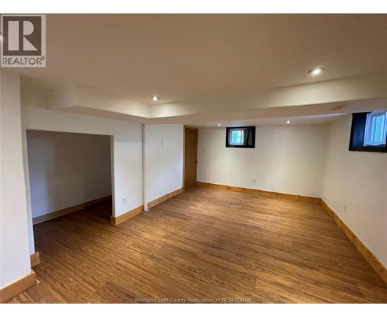 A room with wooden flooring and white walls.