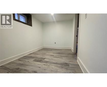 A room with a wooden floor and a window.