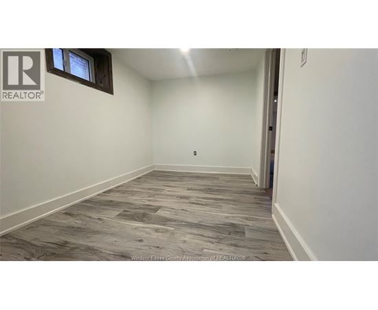 A room with a wooden floor and a window.