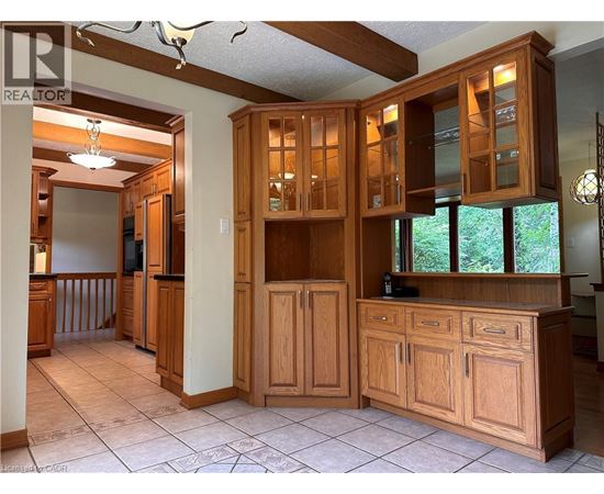 A kitchen with wooden cabinets and a tile floor.