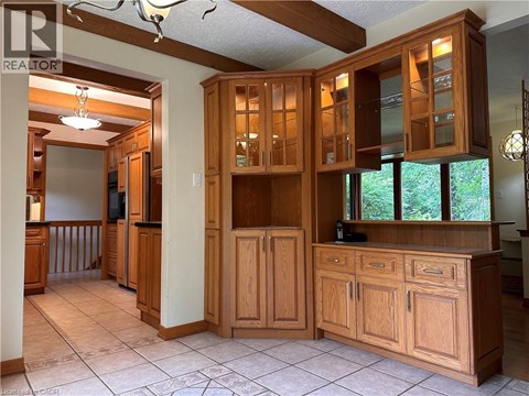 A kitchen with wooden cabinets and a tile floor.