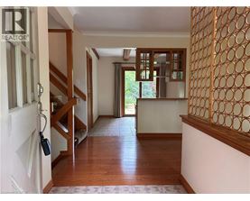 A hallway with a wooden floor and a white door.
