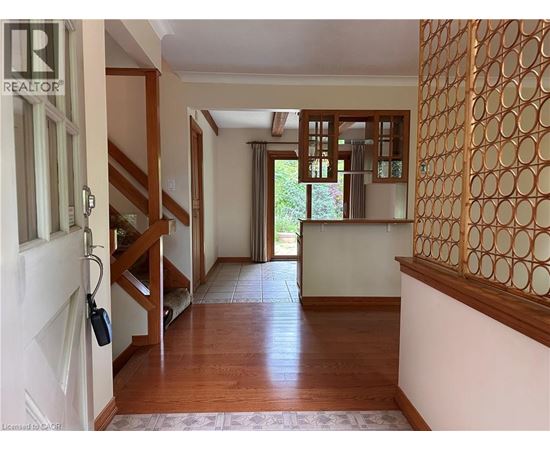 A hallway with a wooden floor and a white door.