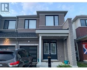 A house with a grey car parked in front.