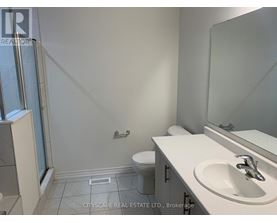 A bathroom with a toilet, sink, and mirror.