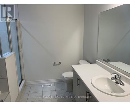 A bathroom with a toilet, sink, and mirror.