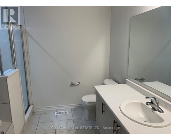 A bathroom with a toilet, sink, and mirror.