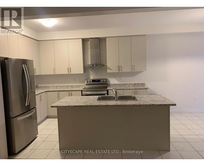 A kitchen with a marble countertop and stainless steel appliances.