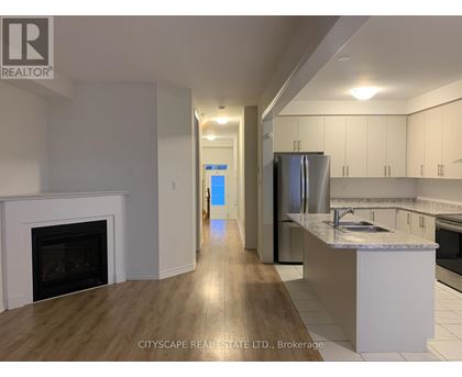 A kitchen with a fireplace and a refrigerator.