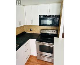 A kitchen with black countertops and white cabinets.