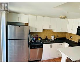 A kitchen with white cabinets and a stainless steel refrigerator.